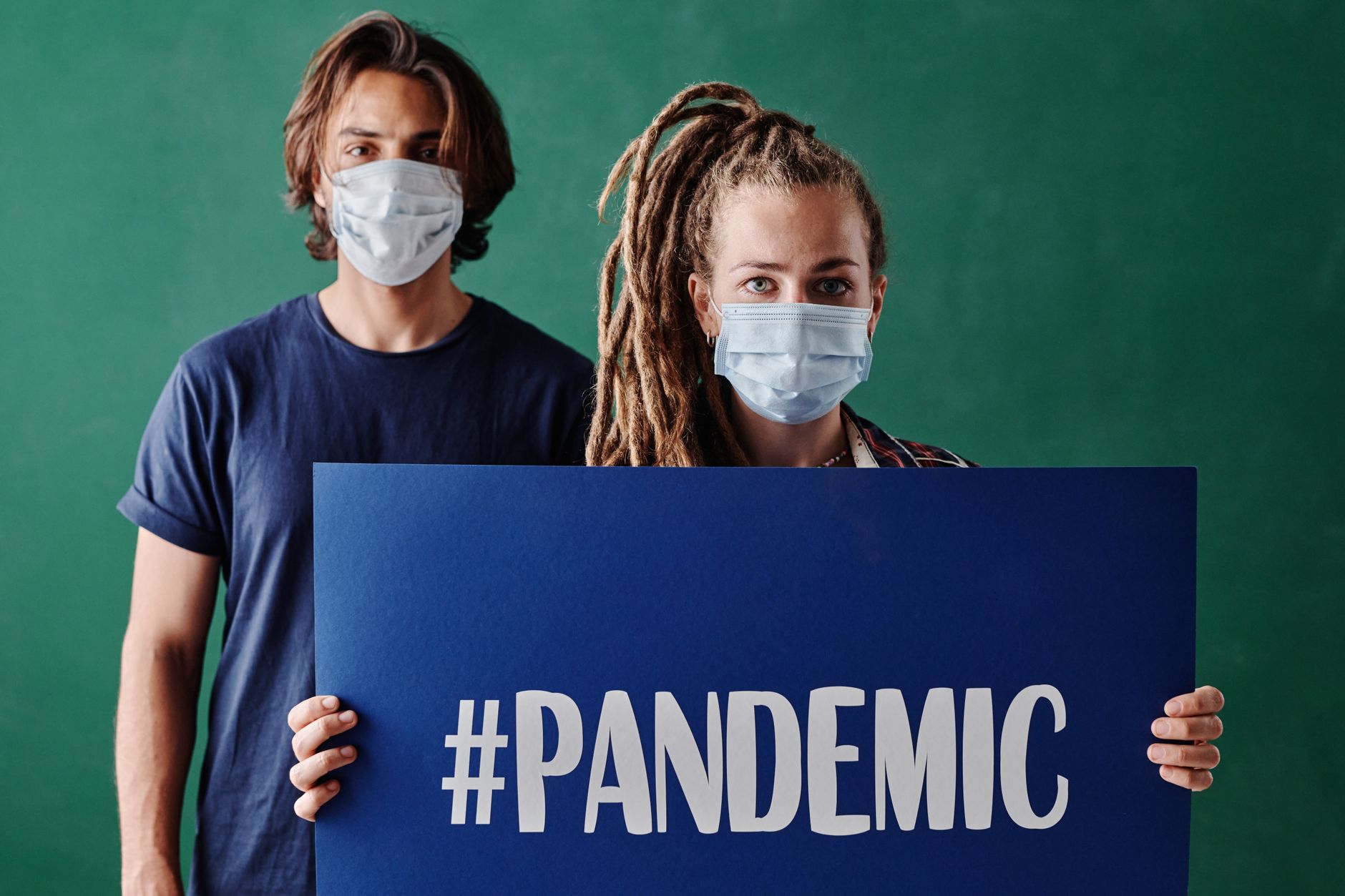 woman wearing face mask holding placard